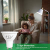 A mother and child sitting together in a cozy living room, reading a book under a floor lamp equipped with a GY LED light bulb.