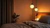 A cozy bed featuring a stylish lamp on its surface, providing soft lighting for the space