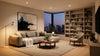 Modern living room with a large beige sofa, abstract art, and floor lamp. A cityscape view through floor-to-ceiling windows at dusk enhances the cozy atmosphere.